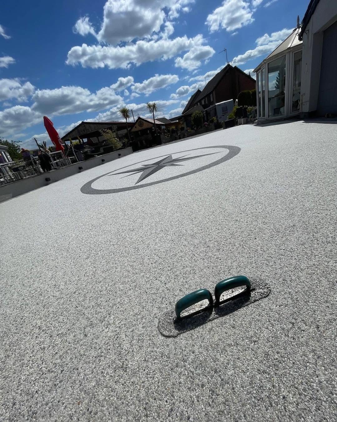 Resin bound surface with an inlaid compass-star feature