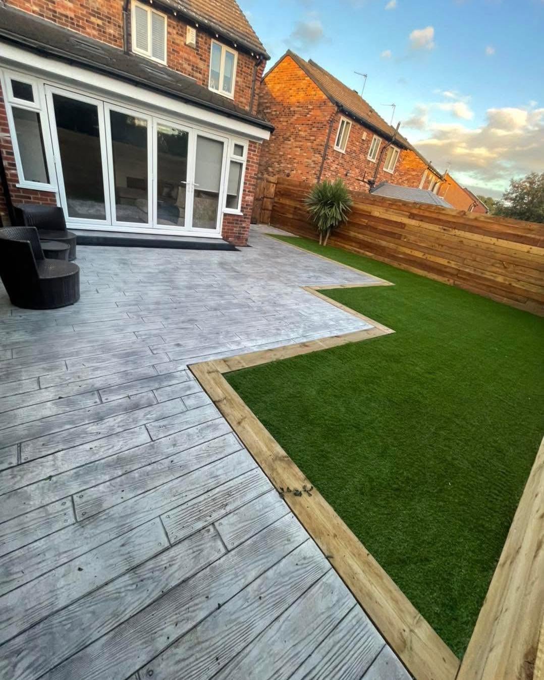 Wood-effect imprinted concrete patio with artificial grass & sleeper edging