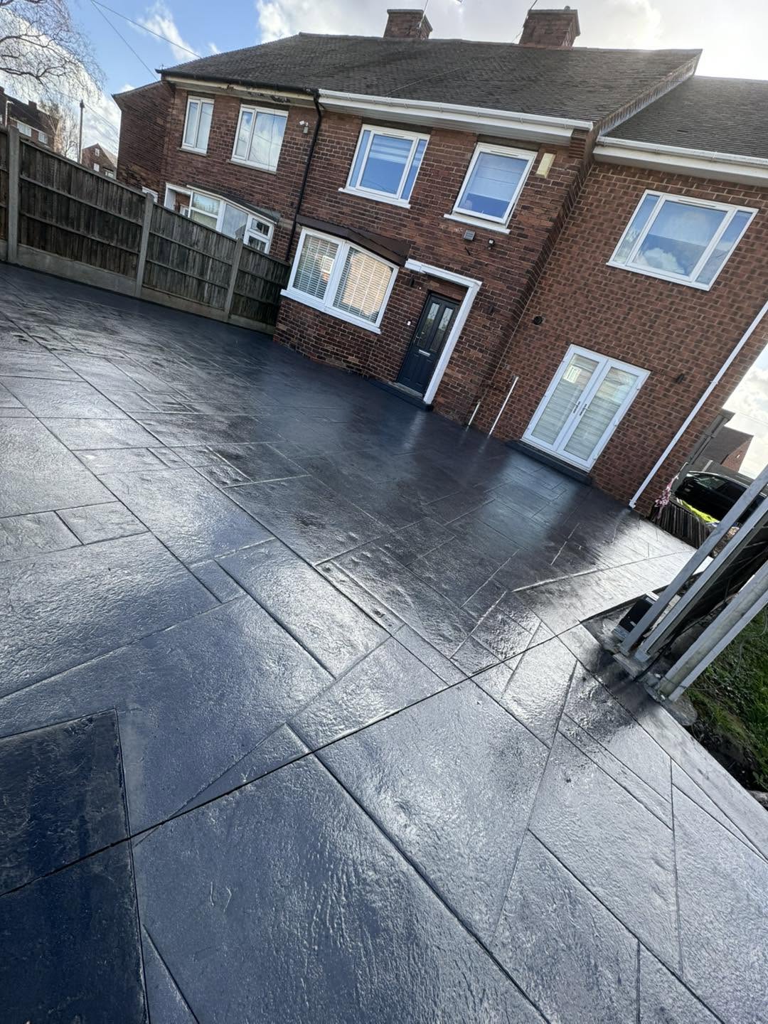Charcoal ashlar imprinted concrete patio with fencing
