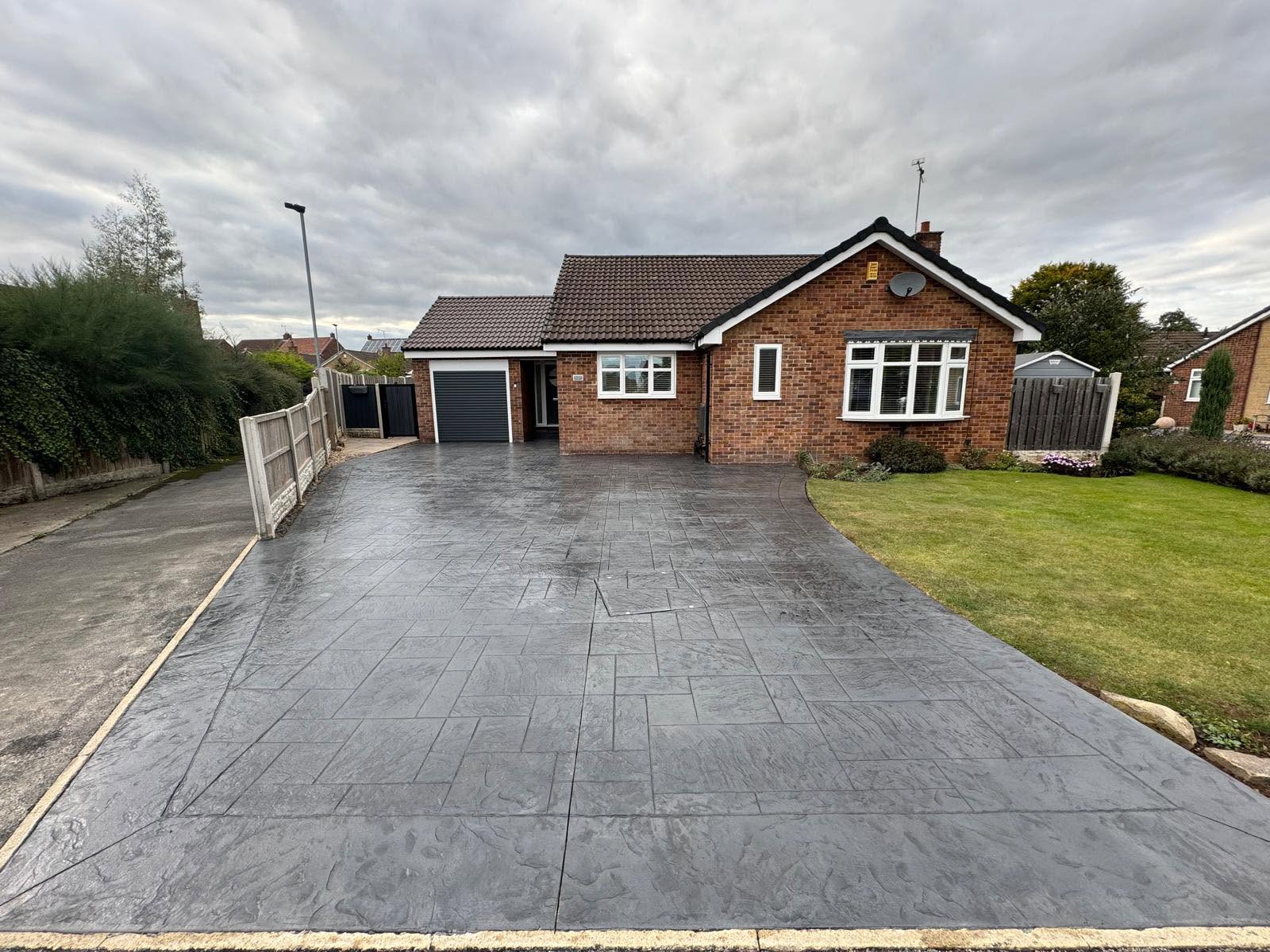 Grey imprinted concrete driveway at a bungalow