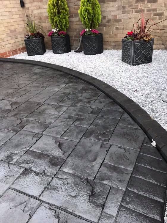 Slate-effect imprinted concrete patio with a charcoal border